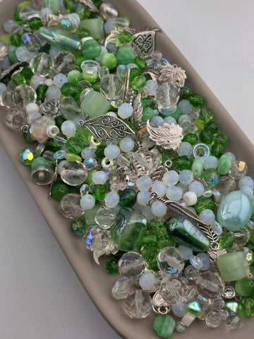 A collection of various colorful beads, gemstones, and metal charms arranged on a surface.