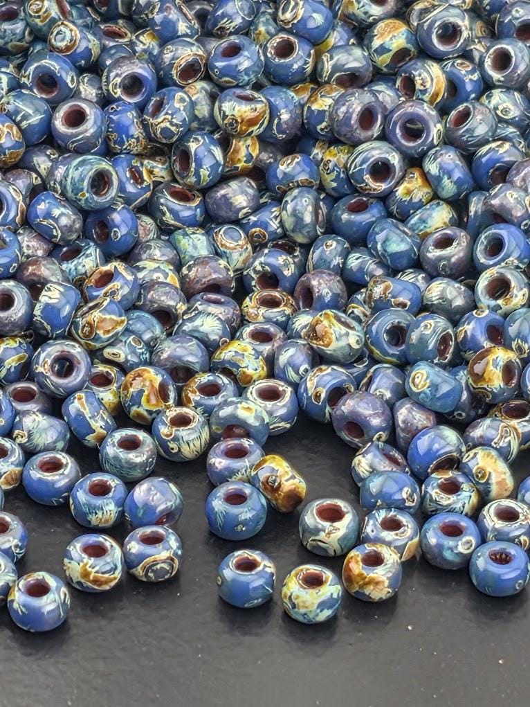 a large pile of colorful, patterned beads scattered on a dark surface.