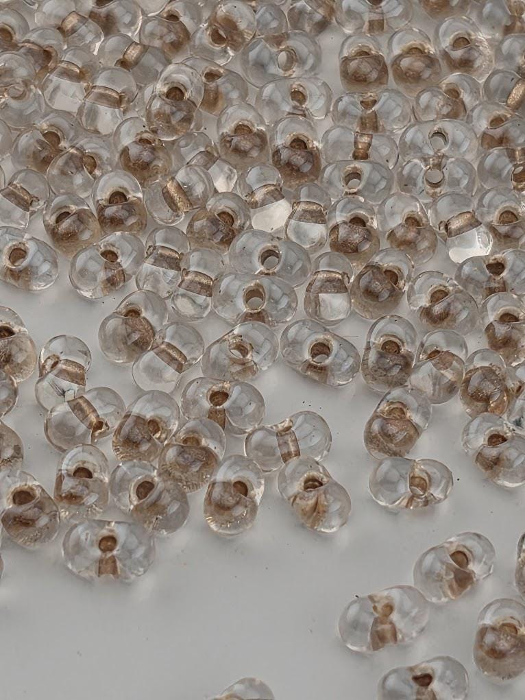 a collection of clear glass beads scattered across a white surface.