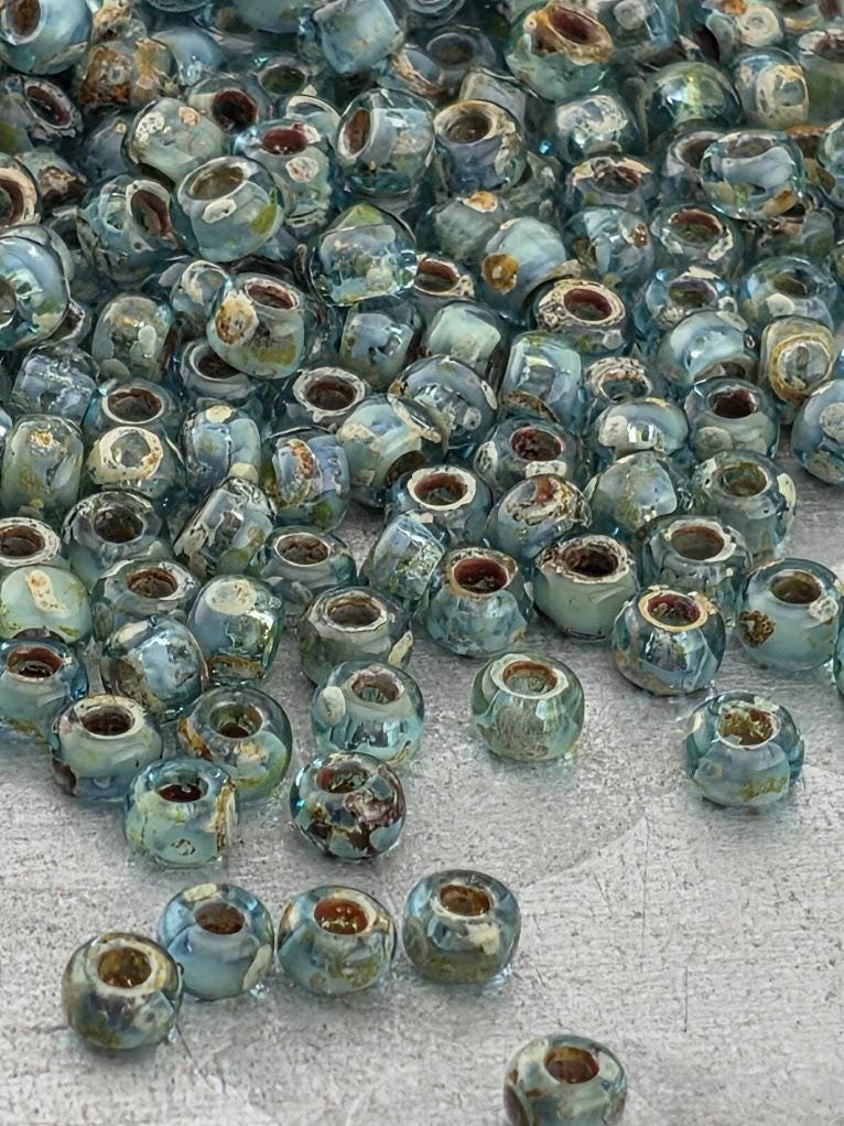 a large pile of small, clear glass beads scattered on a surface.