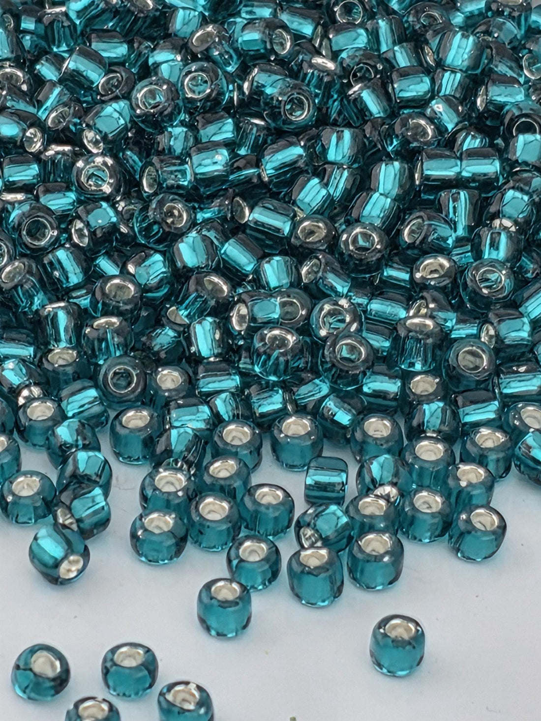 a close-up view of numerous blue and silver beads scattered across a surface.