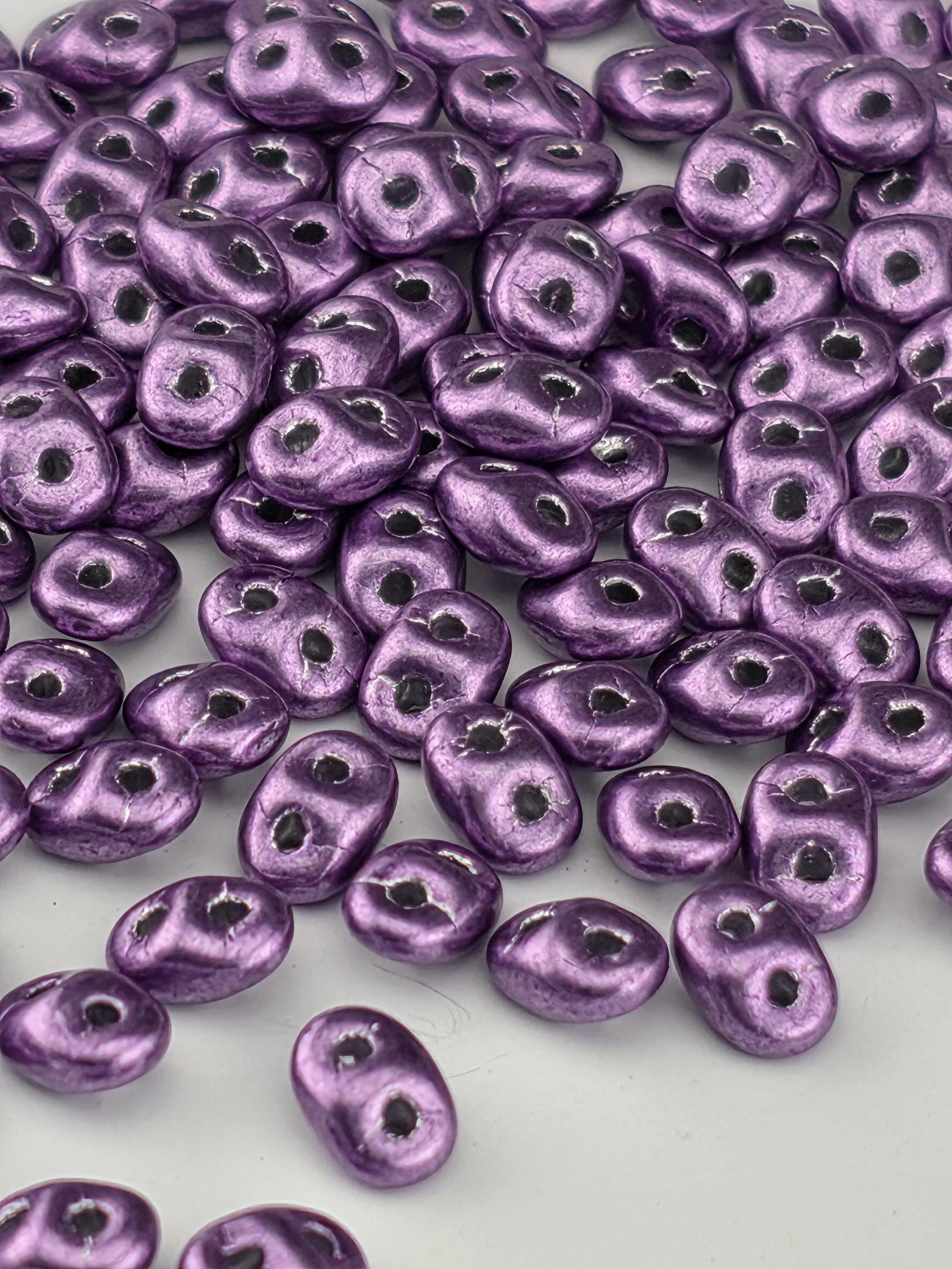 a close-up view of numerous purple beads scattered across a surface.