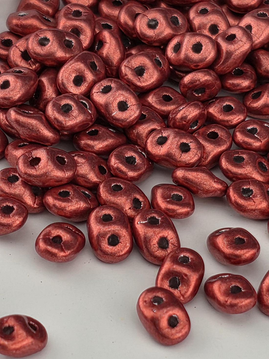 a close-up view of numerous red beads scattered across a surface.