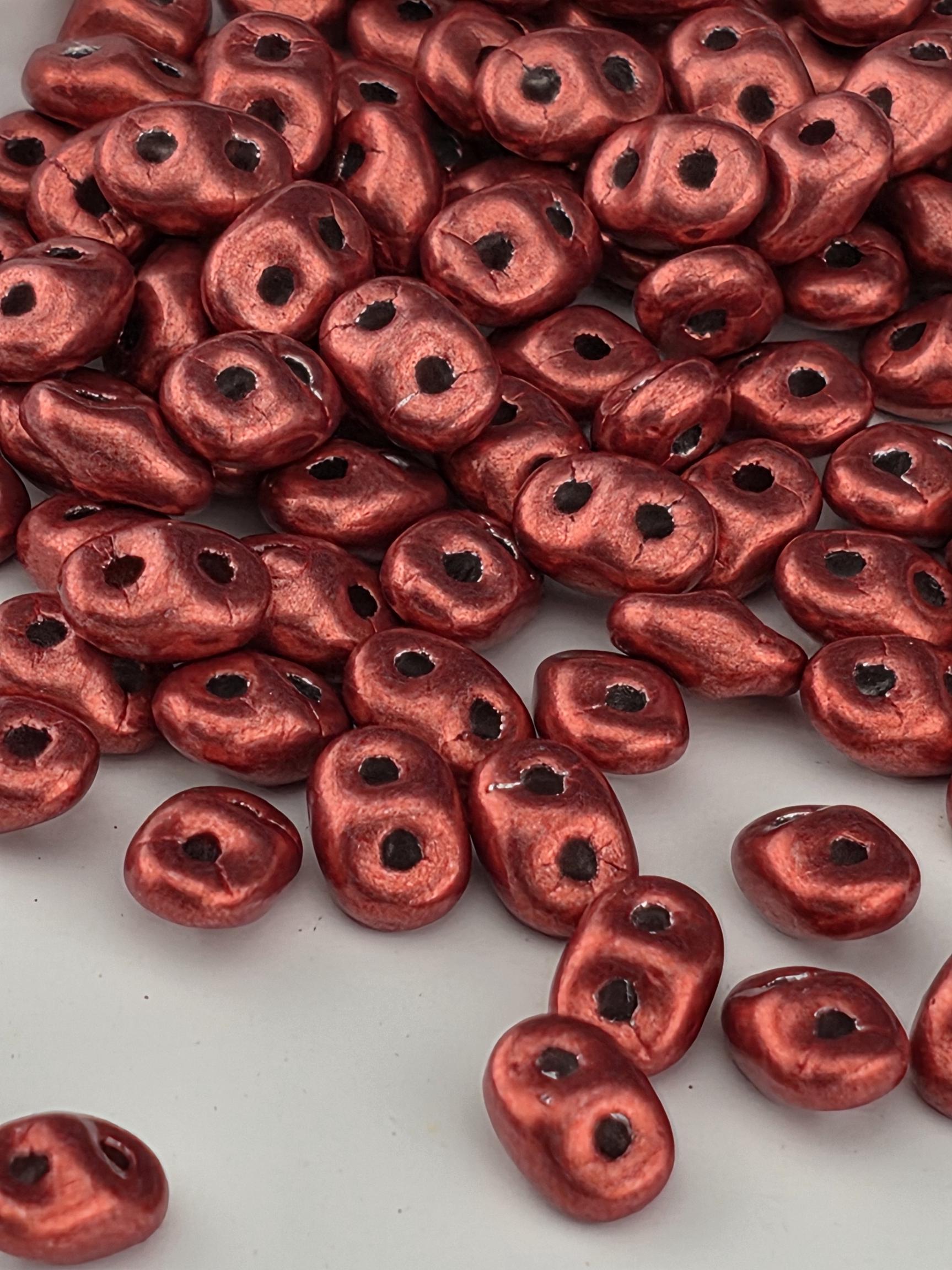 a close-up view of numerous red beads scattered across a surface.