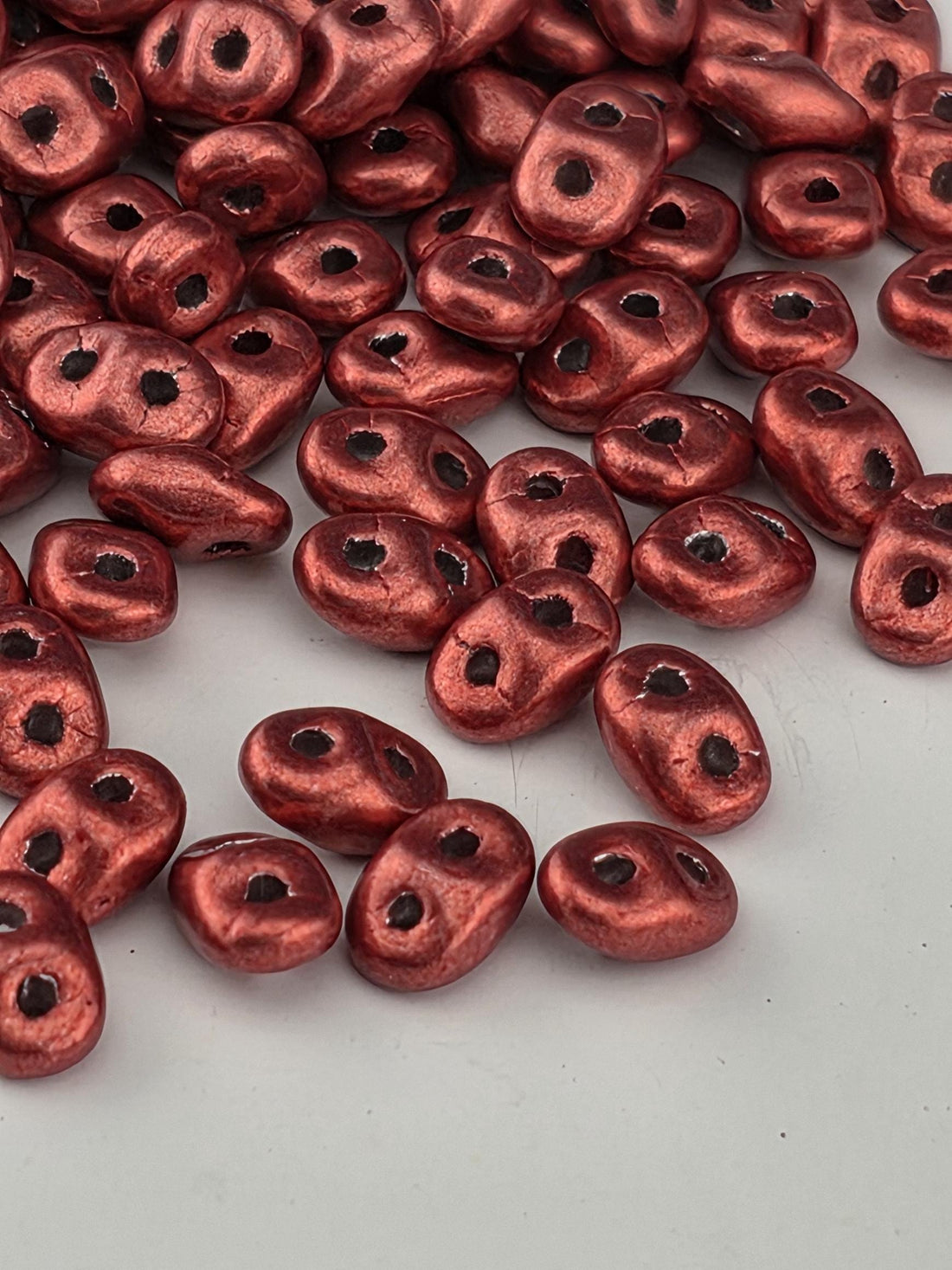 a close-up view of numerous red beads scattered across a surface.