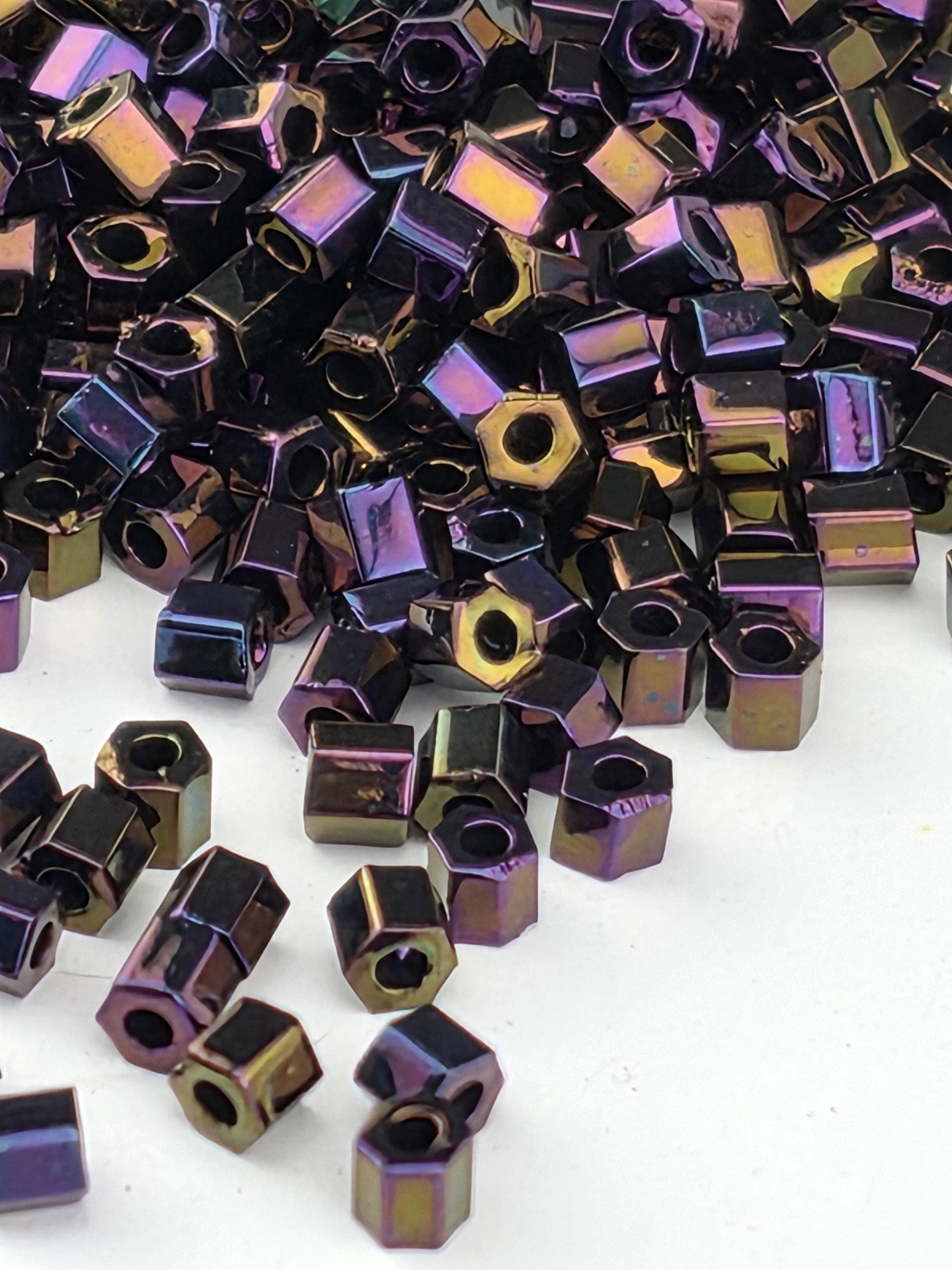 a collection of small, multicolored metal nuts or bolts scattered on a white background.