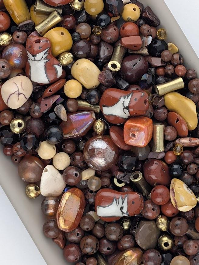 The image is a collection of various beads and beads, including different shapes, sizes, and colors, arranged in a visually appealing manner.