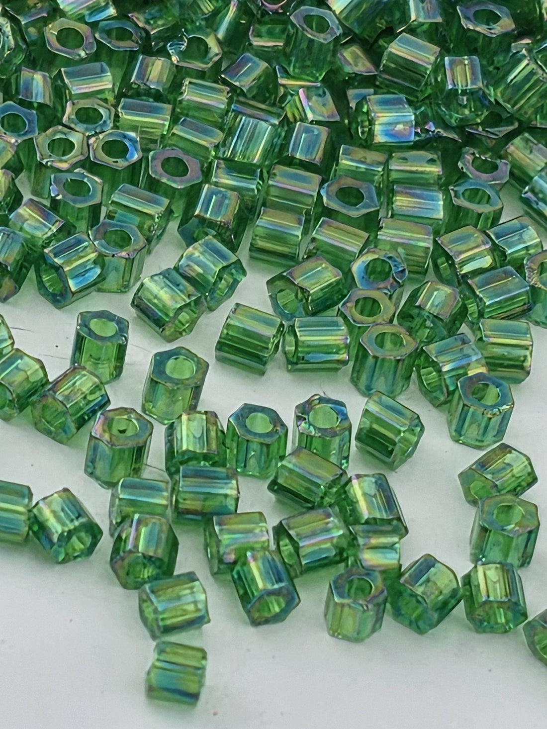a collection of green glass beads scattered across a surface.