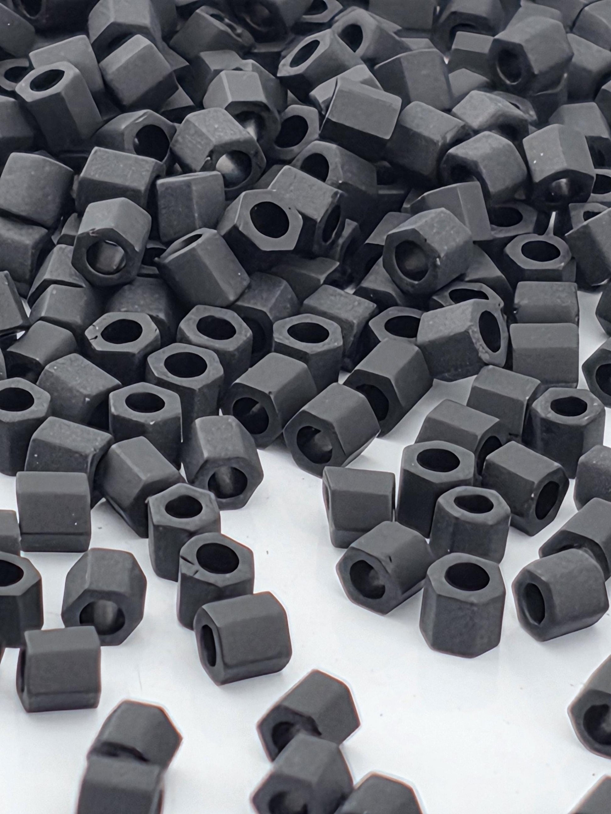 numerous black hexagonal nuts or bolts scattered across a white background.