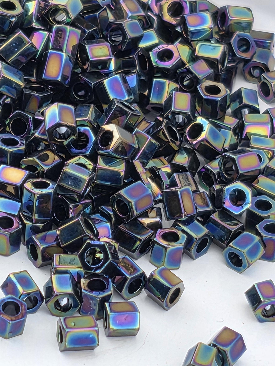 a close-up view of numerous hexagonal metal nuts or bolts scattered across a surface.