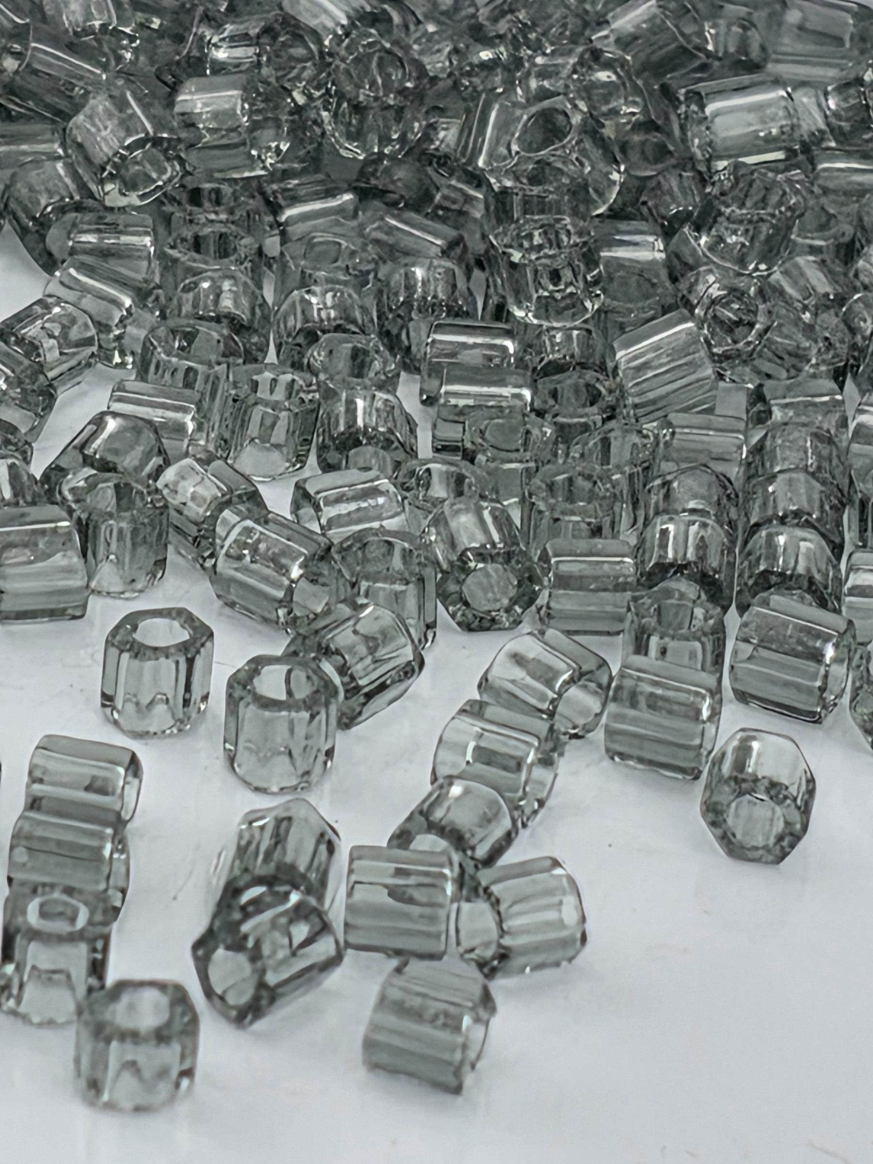 numerous small, clear glass beads scattered across a surface.