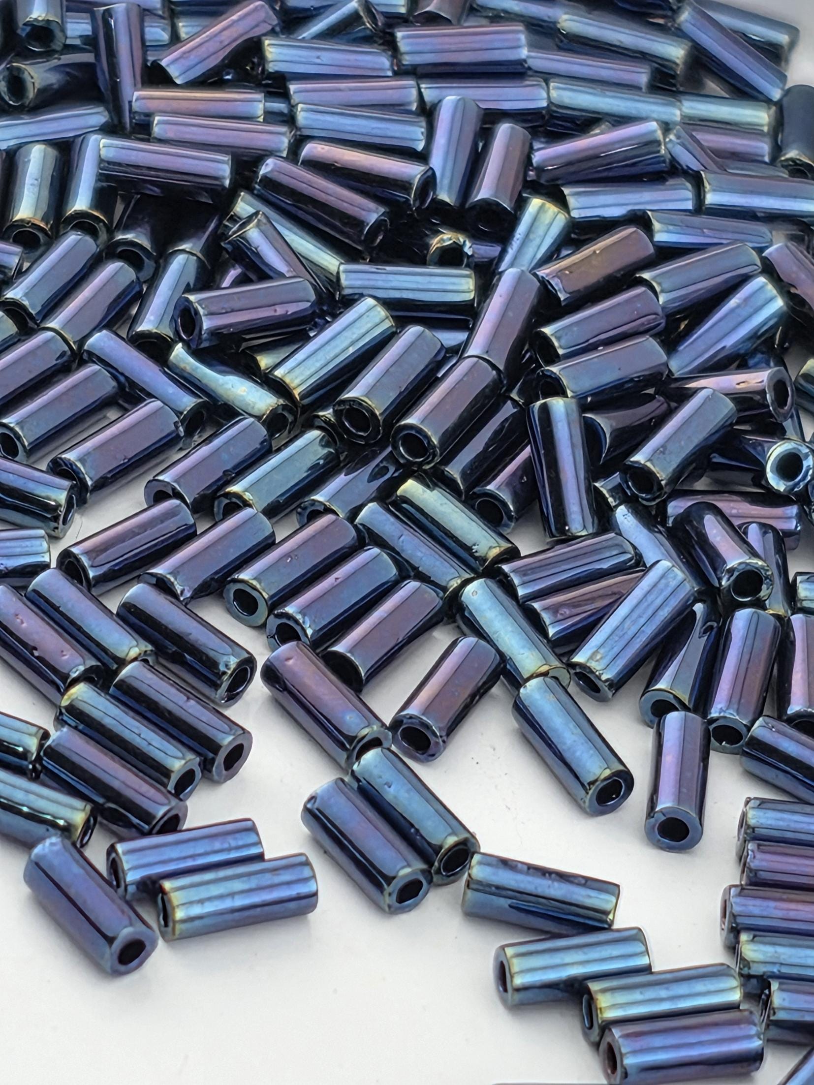 a close-up view of numerous blue and purple beads or rods scattered across a surface.