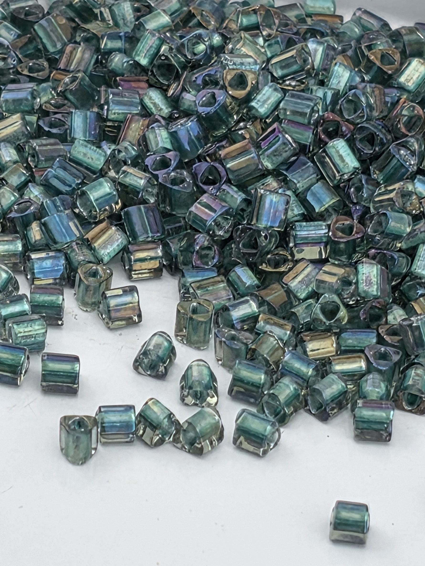 a pile of multicolored glass beads scattered on a white surface.