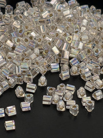 a pile of clear, transparent beads scattered on a dark background.