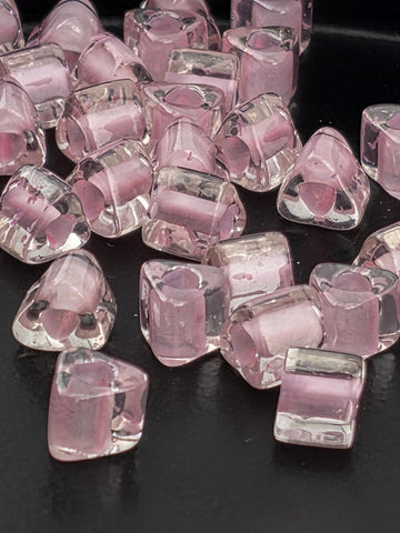 a collection of clear, transparent glass beads scattered on a dark background.