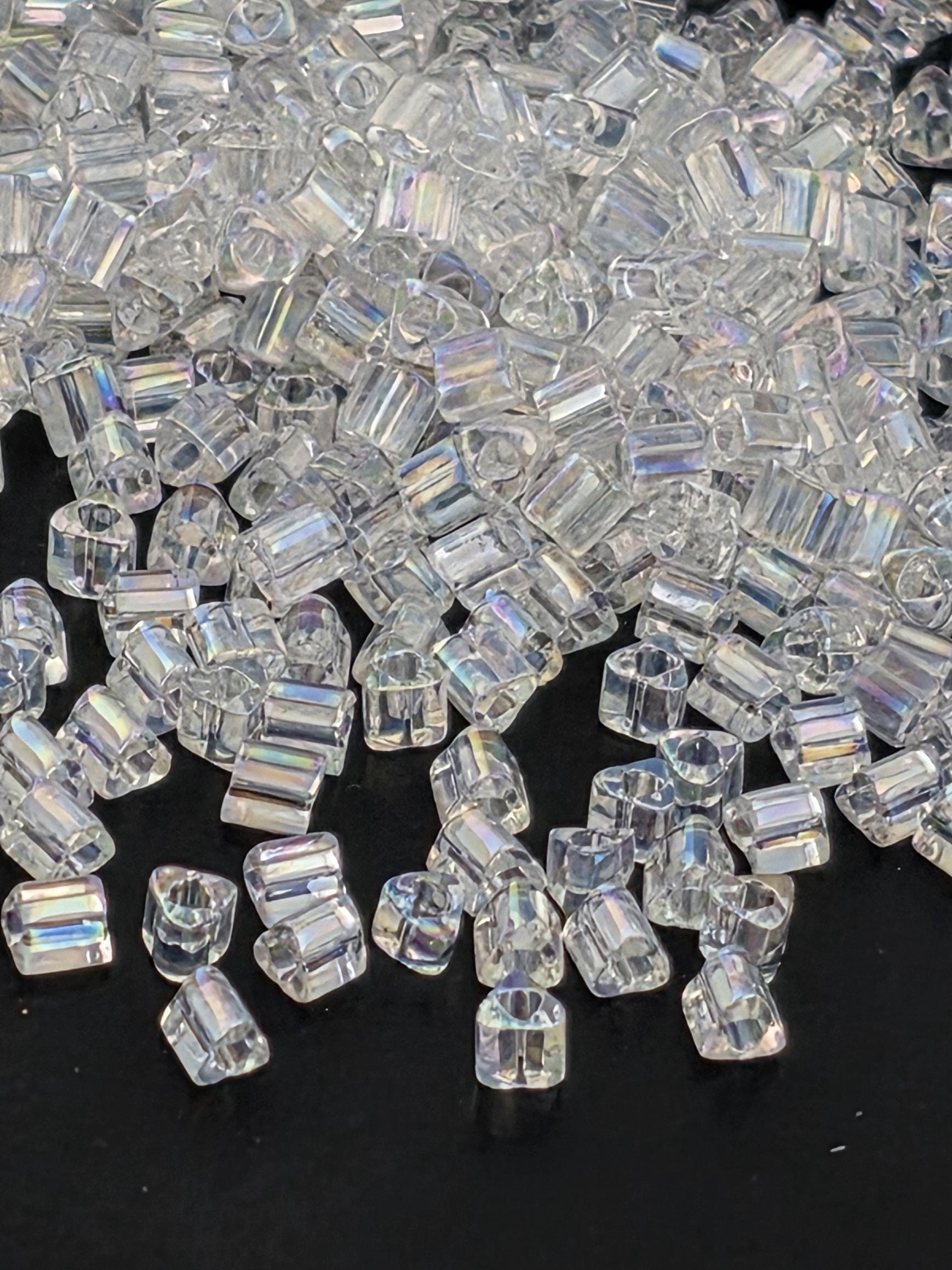 a close-up view of numerous clear, transparent beads scattered across a dark background.