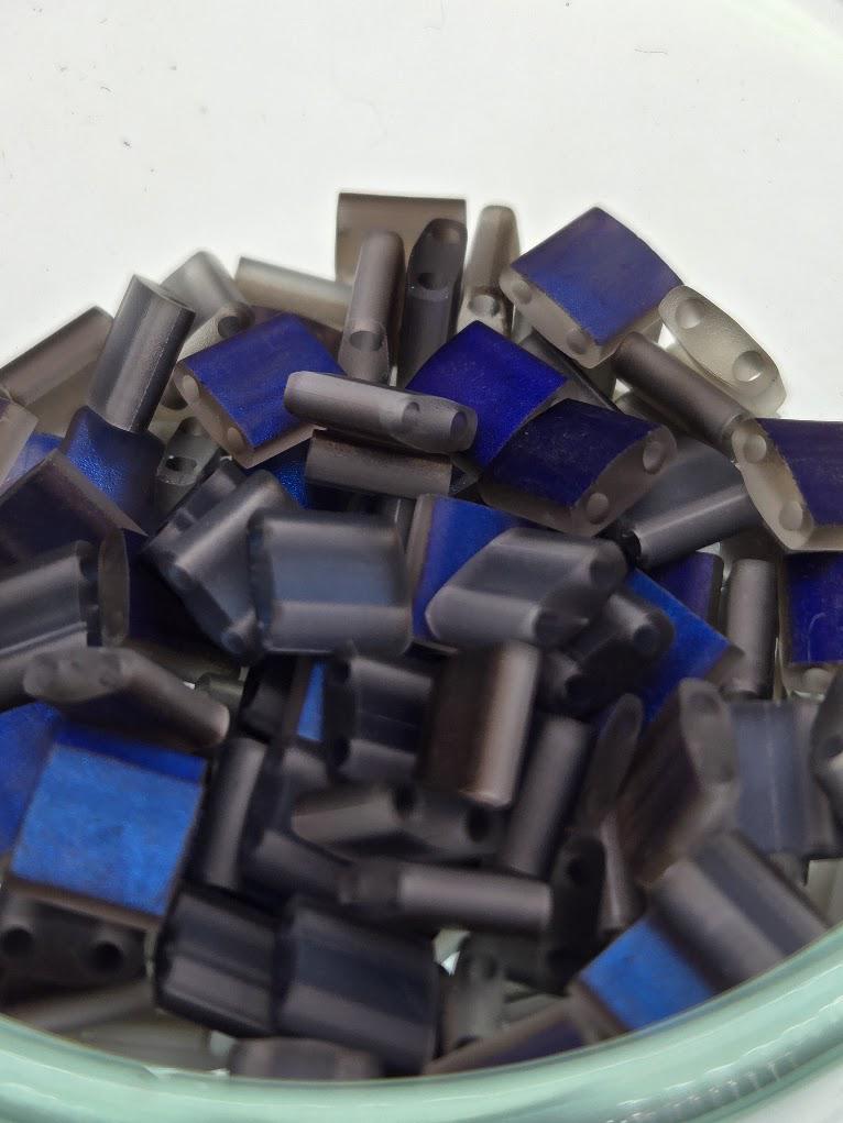 A close-up image of a pile of small, metallic objects in shades of blue and gray.