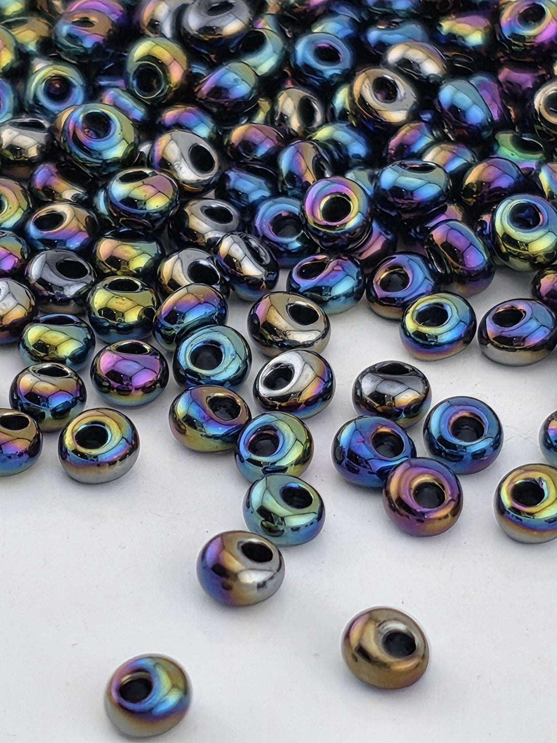 a collection of multicolored glass beads scattered on a white surface.
