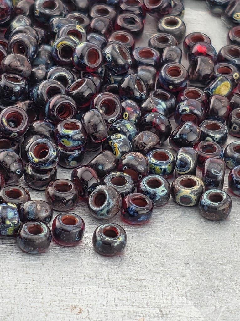 a large pile of multicolored glass beads scattered on a surface.