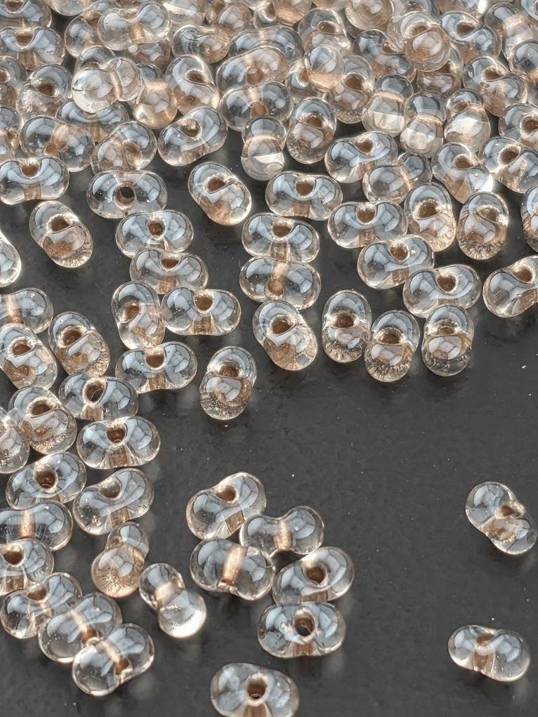a collection of clear glass beads scattered across a white surface.