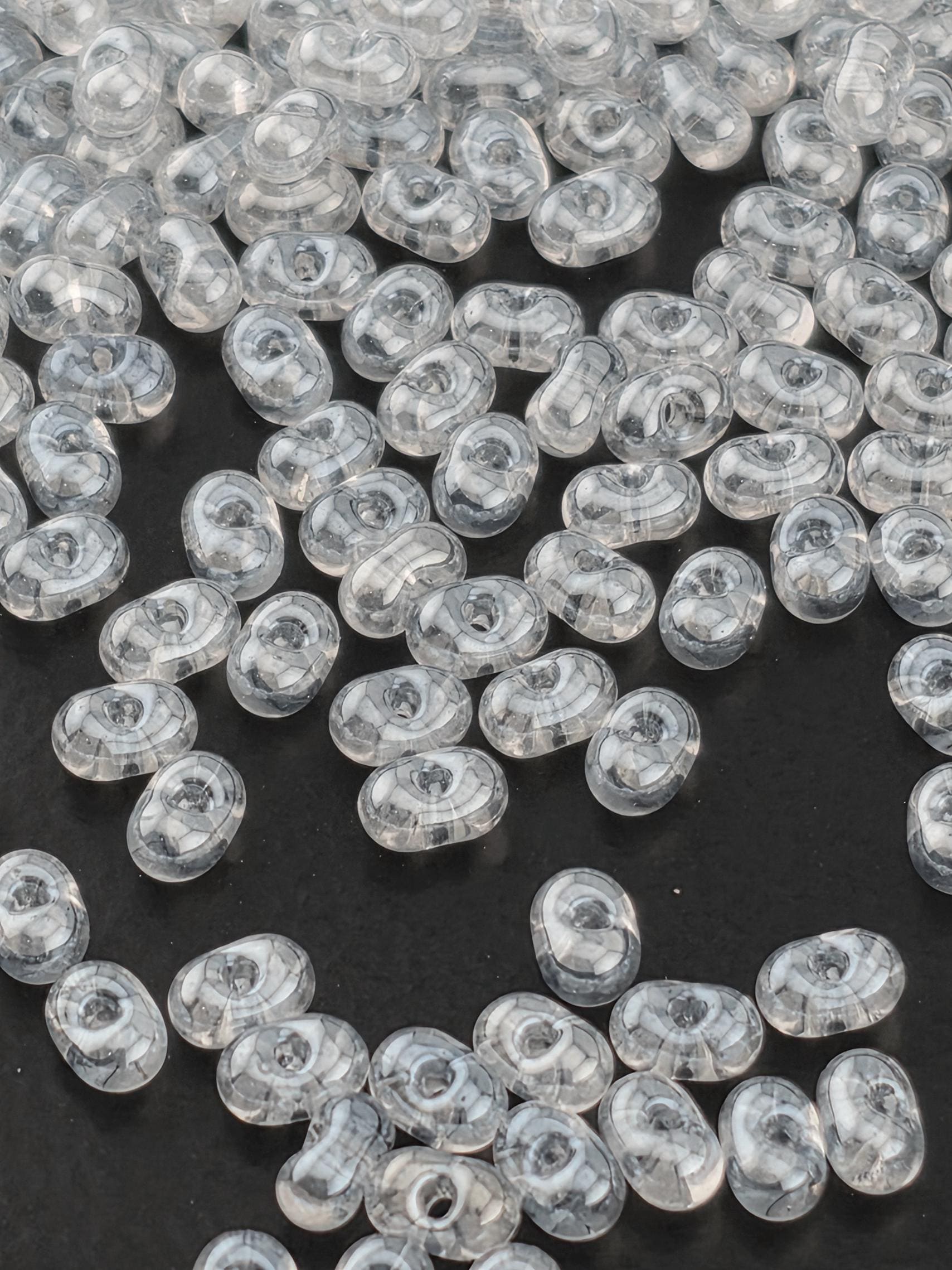 numerous transparent beads scattered across a dark background.