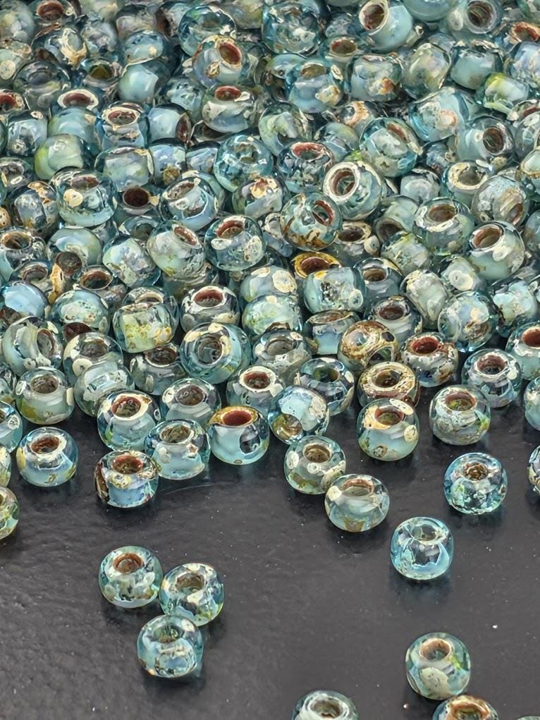 a large pile of small, clear glass beads scattered on a dark surface.