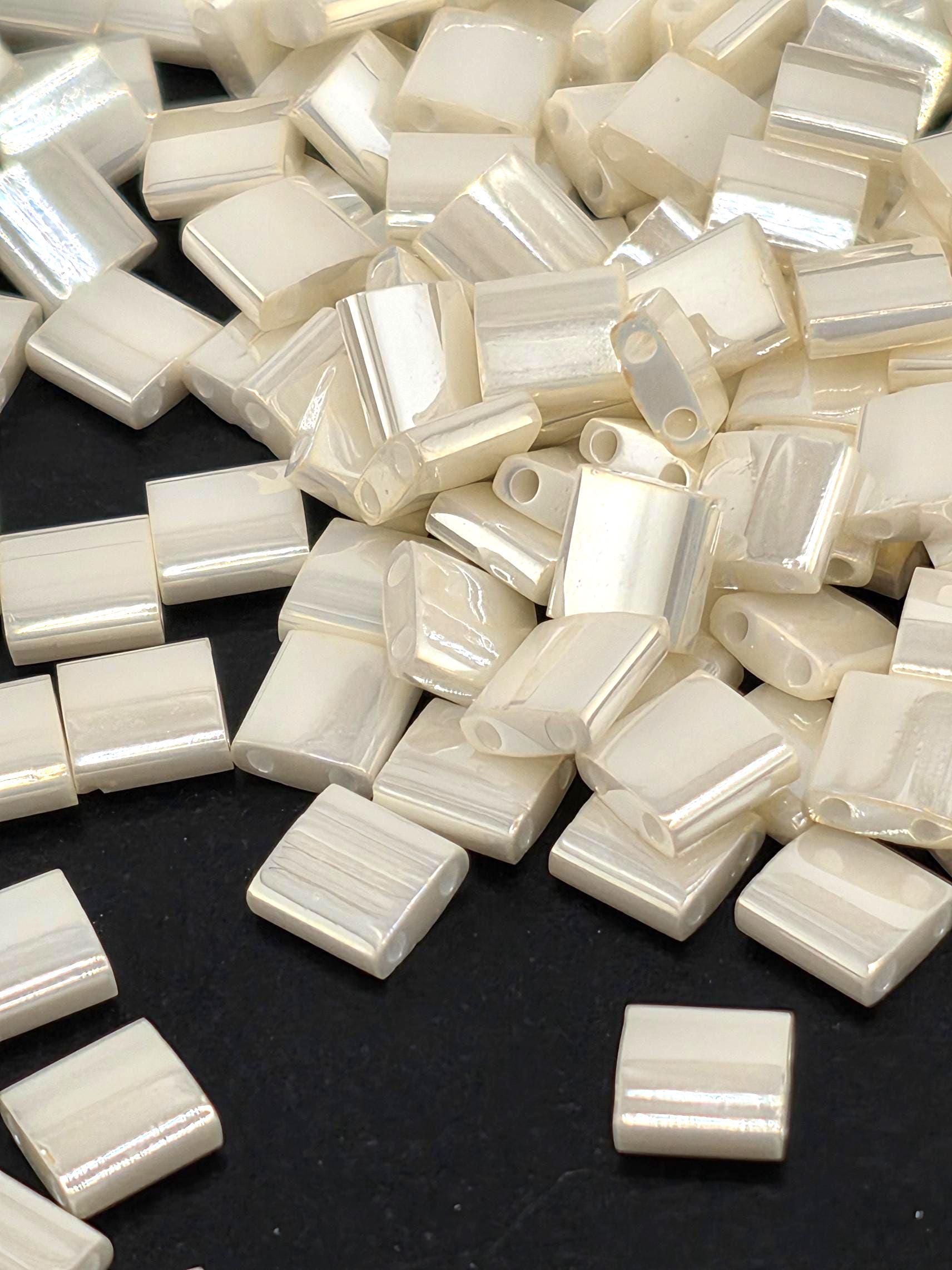 a close-up view of numerous small, white, rectangular objects scattered across a dark background.