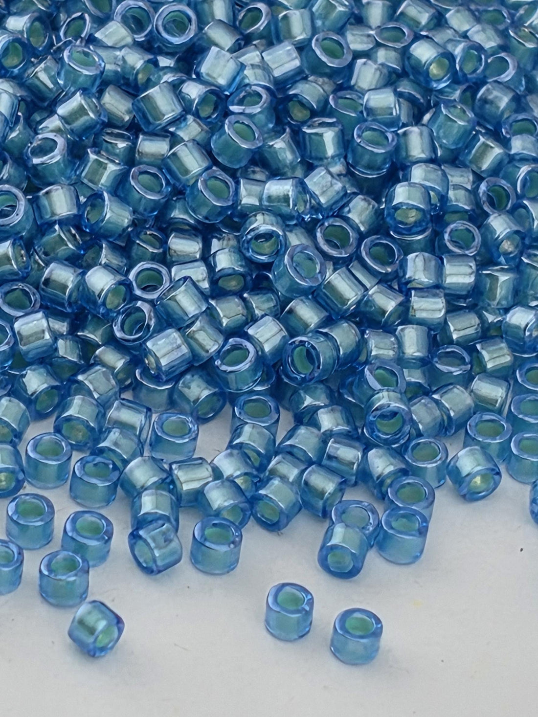 a close-up view of numerous small, clear blue beads scattered across a surface.