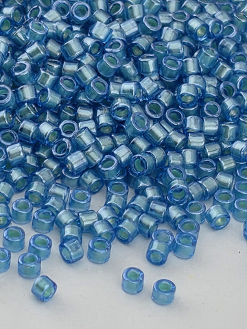 a close-up view of numerous small, clear blue beads scattered across a surface.
