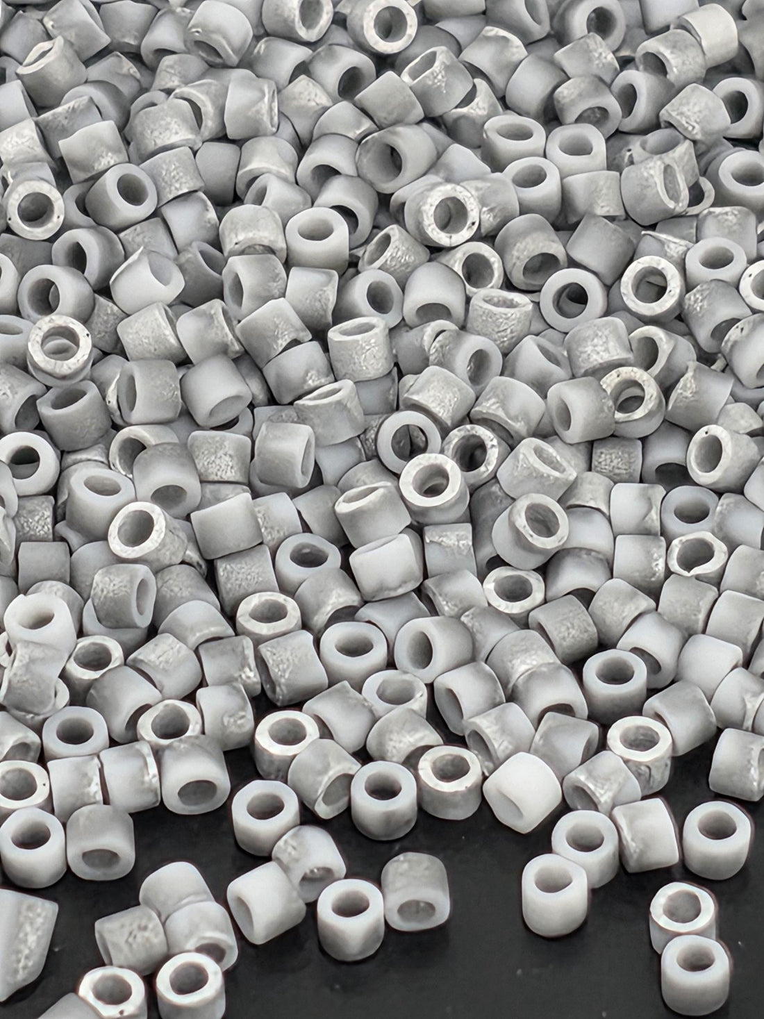 numerous small, white, circular objects scattered across a dark background.