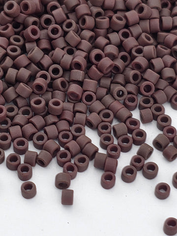 a large pile of brown beads or objects scattered on a white surface.