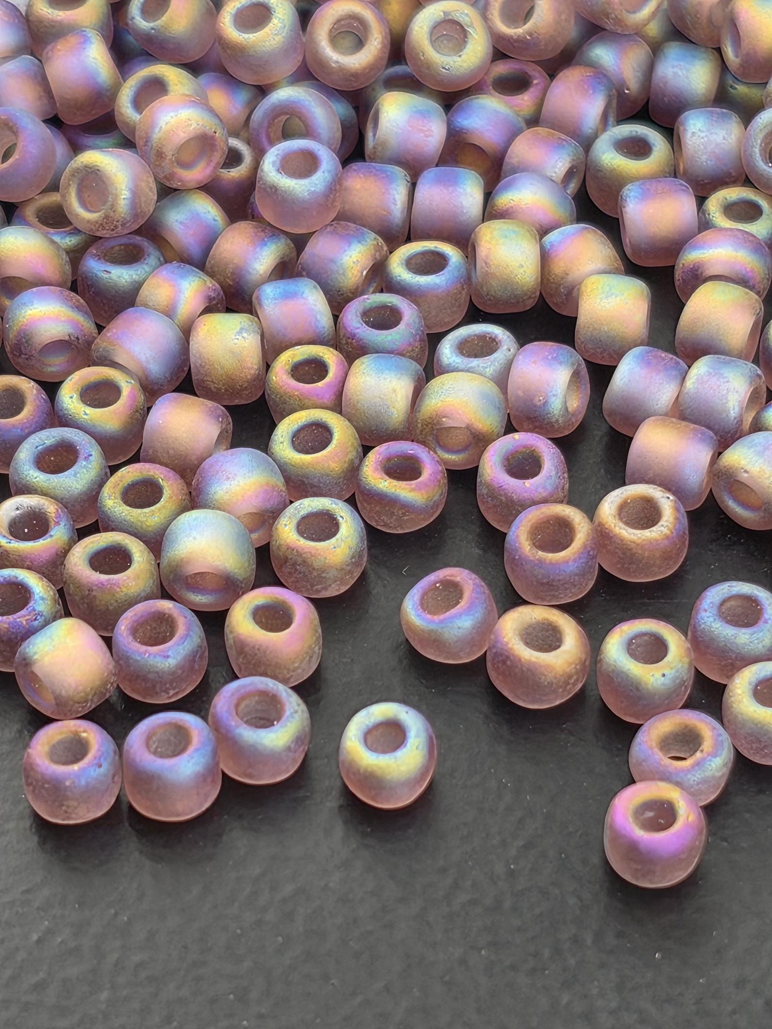 a collection of multicolored glass beads scattered on a dark surface.
