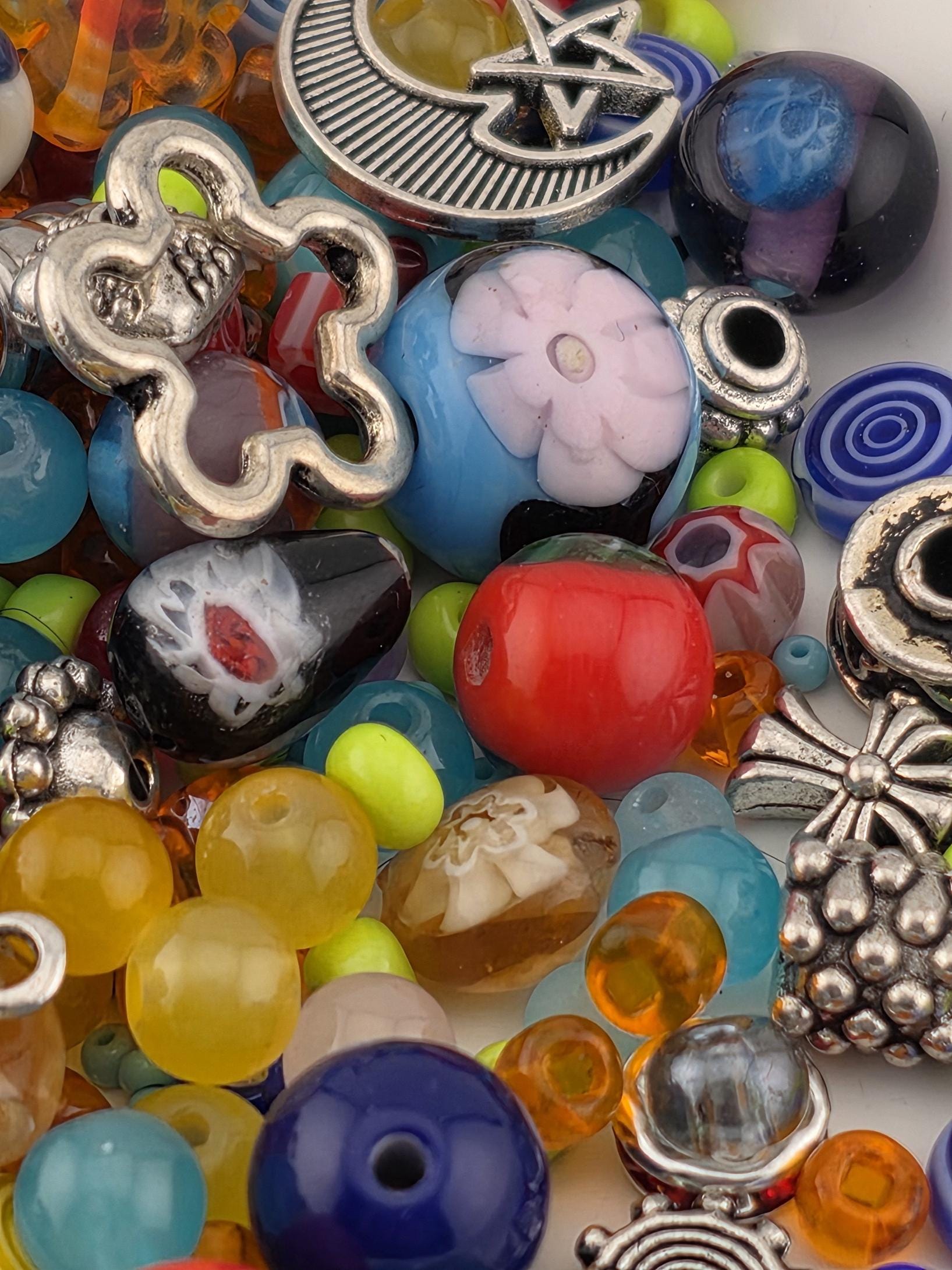 A colorful assortment of beads, charms, and other decorative items, including beads, charms, and other decorative elements, are scattered across the image.
