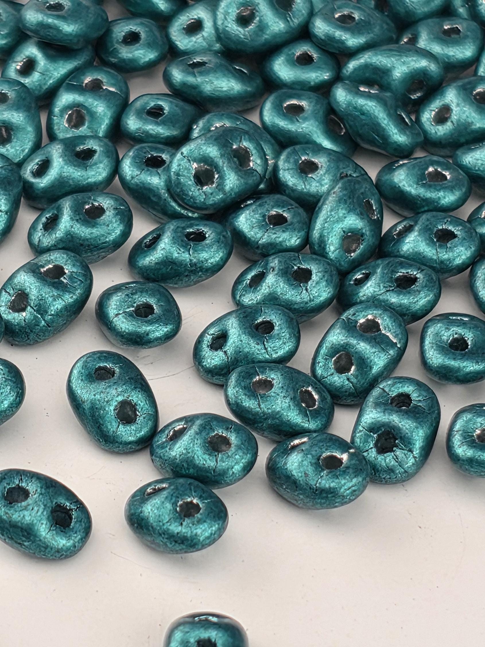 a collection of turquoise-colored beads scattered across a white background.
