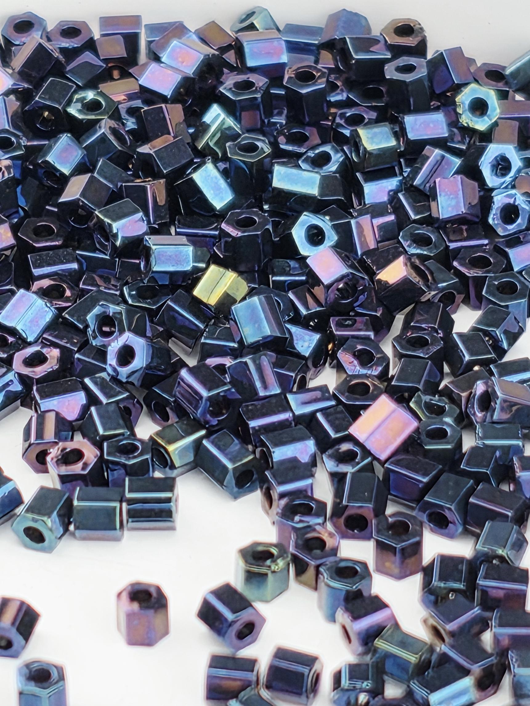 The image is a close-up of numerous small, metallic beads or nuts scattered across a surface.