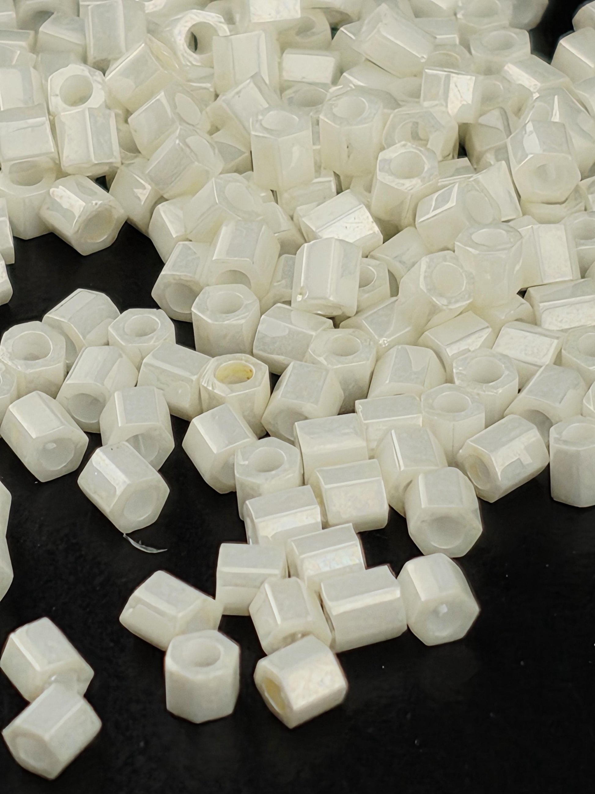 numerous small white hexagonal objects scattered across a dark background.