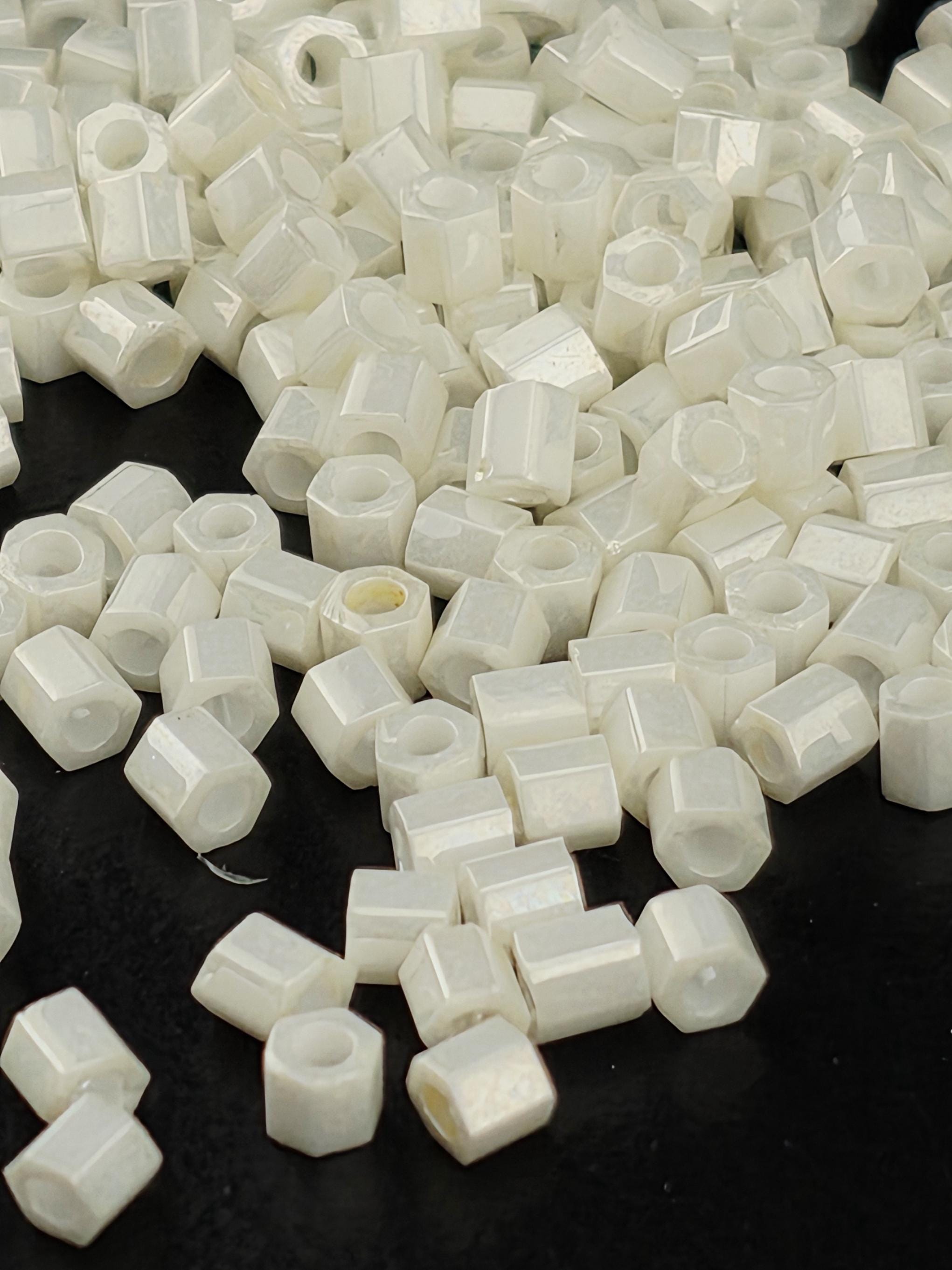 numerous small white hexagonal objects scattered across a dark background.