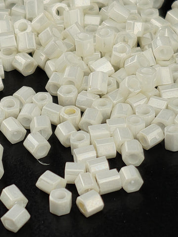 numerous small white hexagonal objects scattered across a dark background.