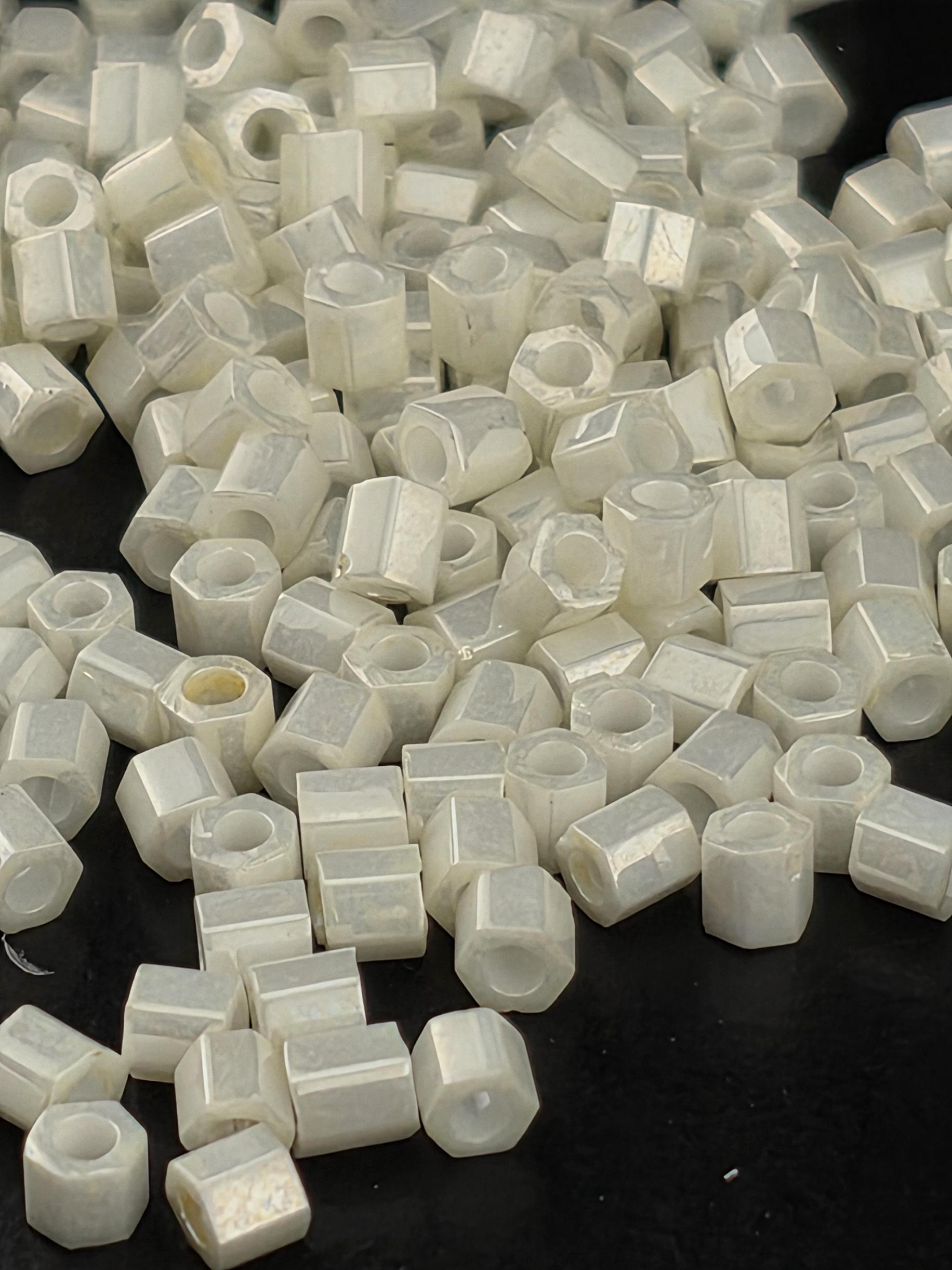 numerous small, white hexagonal objects scattered across a dark background.