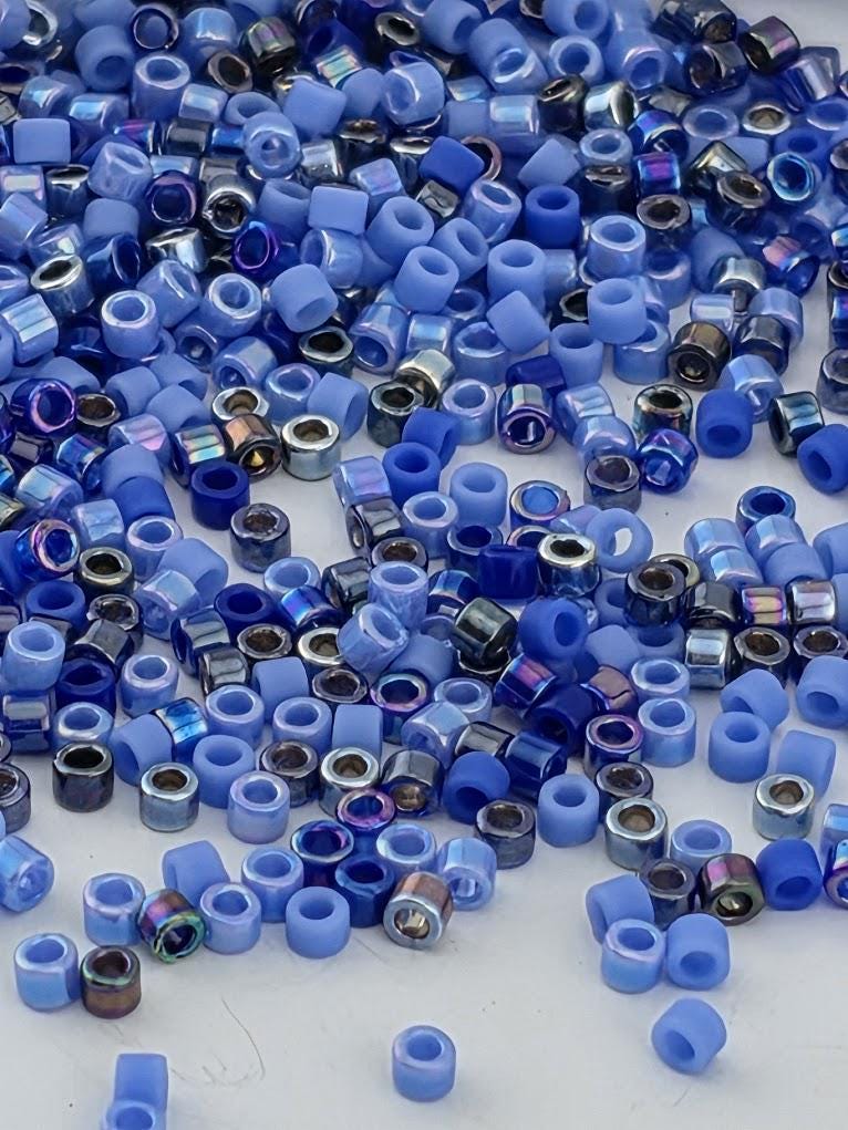 The image is a collection of various blue and silver beads scattered across a surface.