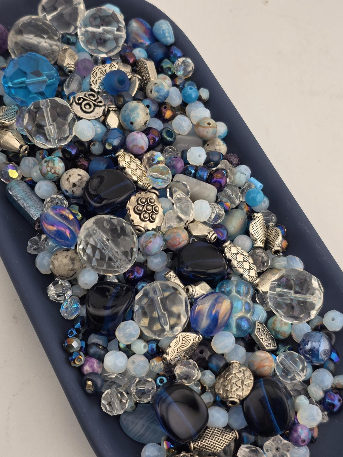 The image is a close-up of various beads and glass beads, showcasing a diverse collection of colors and shapes.