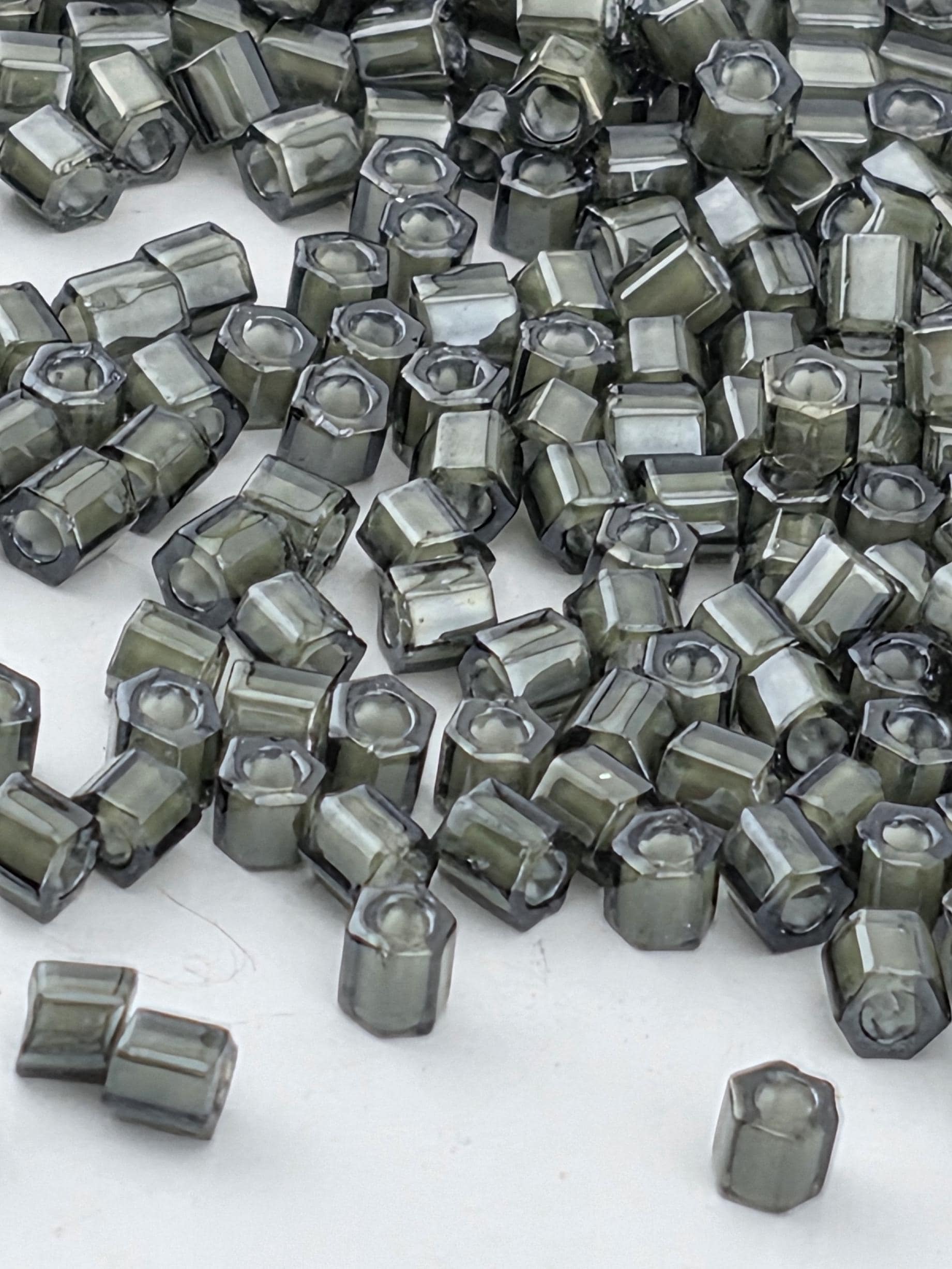 a collection of small, dark-colored hexagonal objects scattered across a white background.