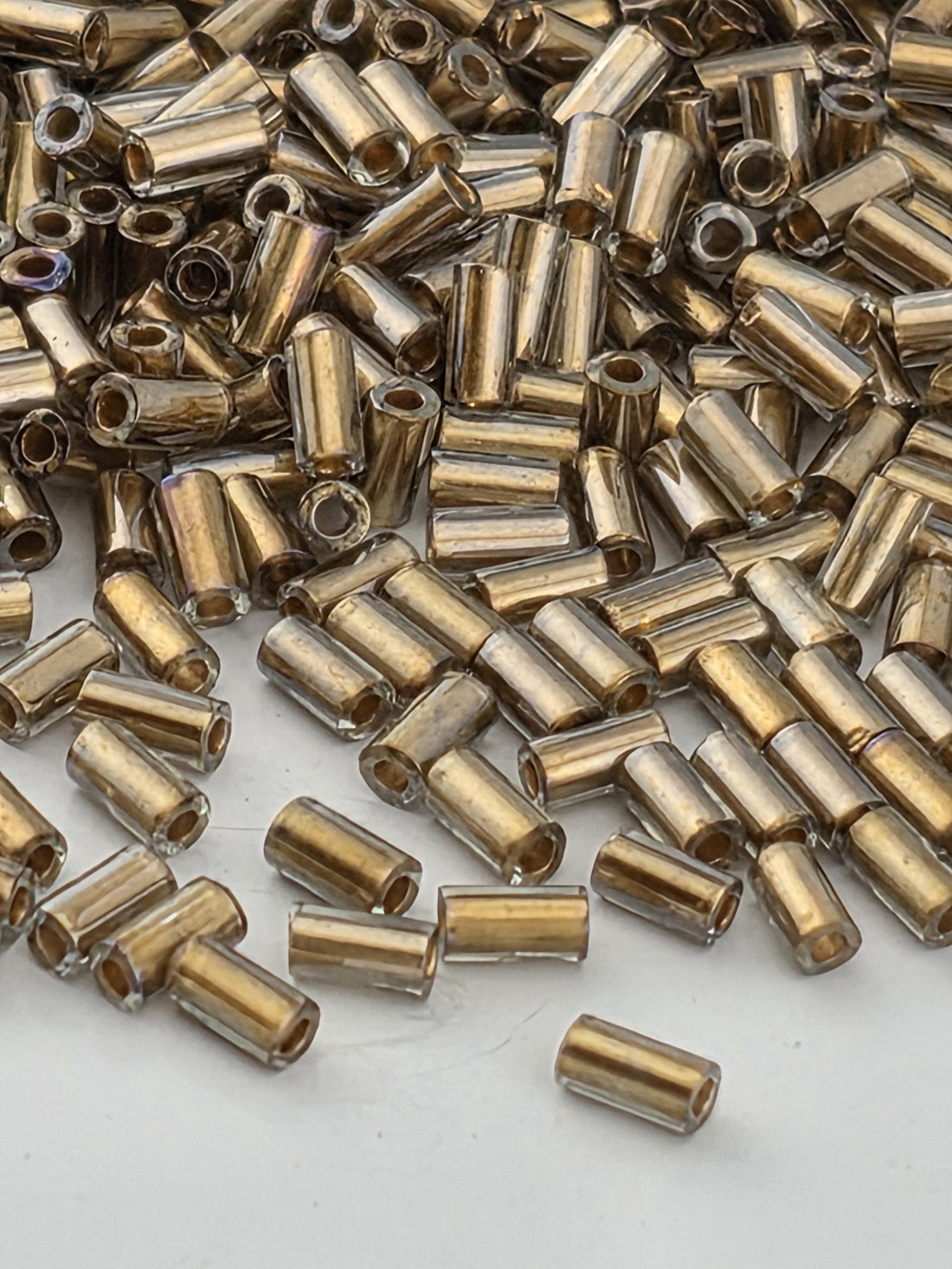 numerous small, cylindrical objects that appear to be made of a shiny, metallic material. They are scattered across a surface, creating a visually interesting and somewhat chaotic arrangement.