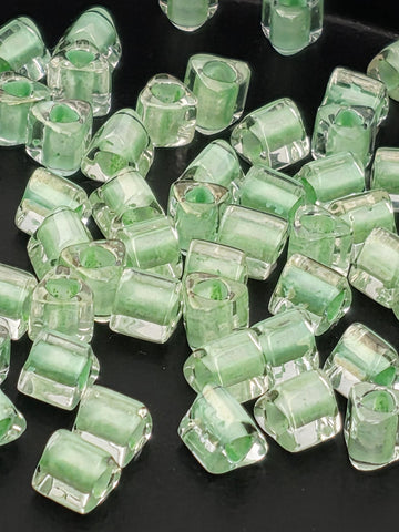 a collection of clear glass beads scattered on a dark background.