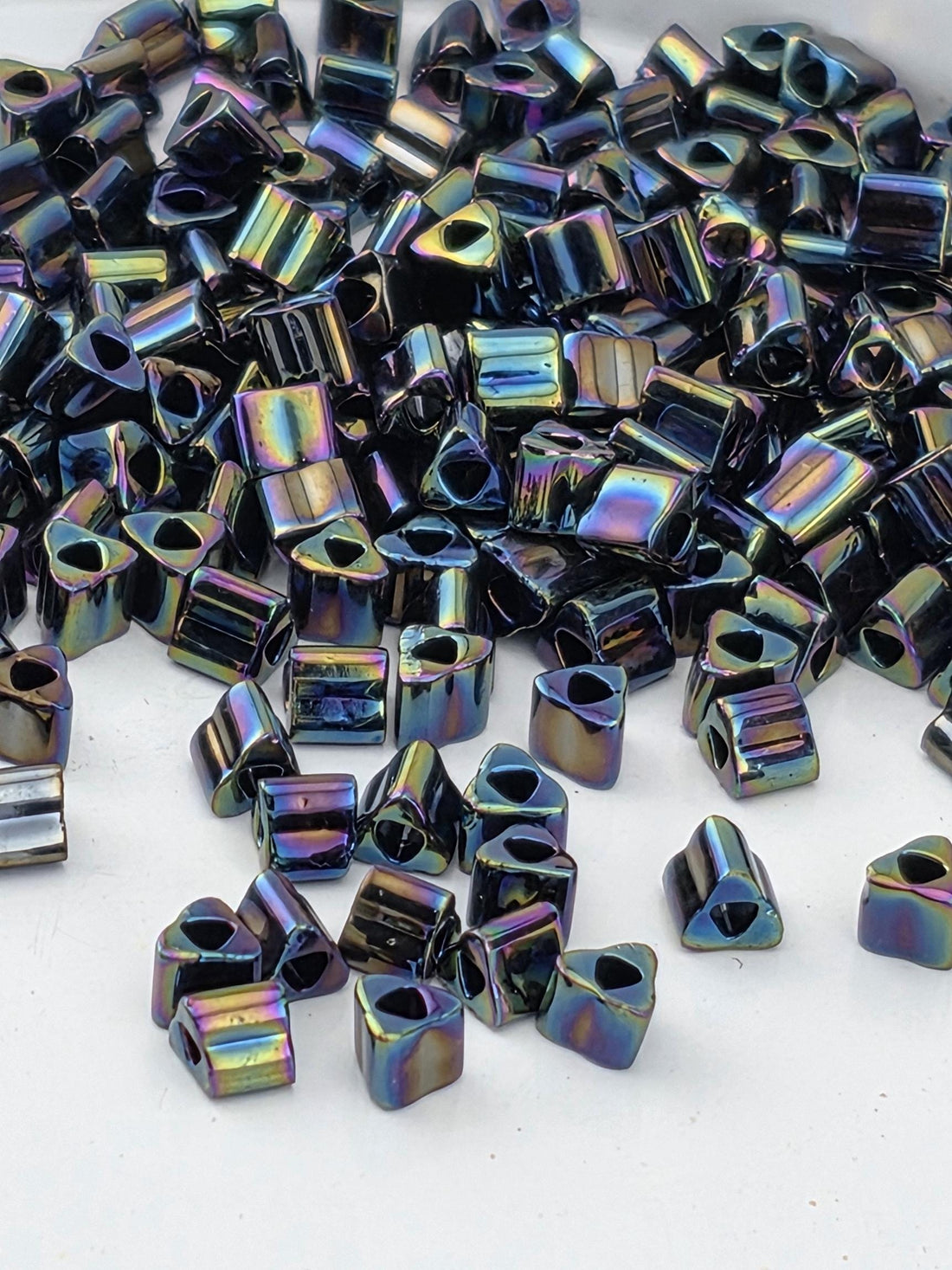 a pile of multicolored glass beads or glass pieces scattered on a white surface.