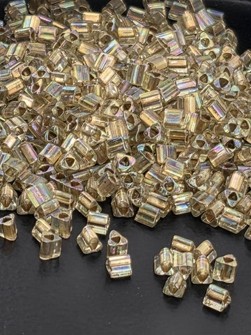 a large pile of small, clear beads scattered on a dark surface.