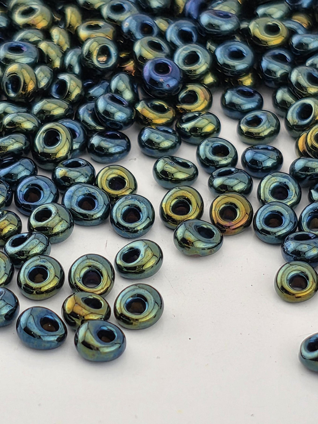a collection of colorful beads scattered on a white surface.