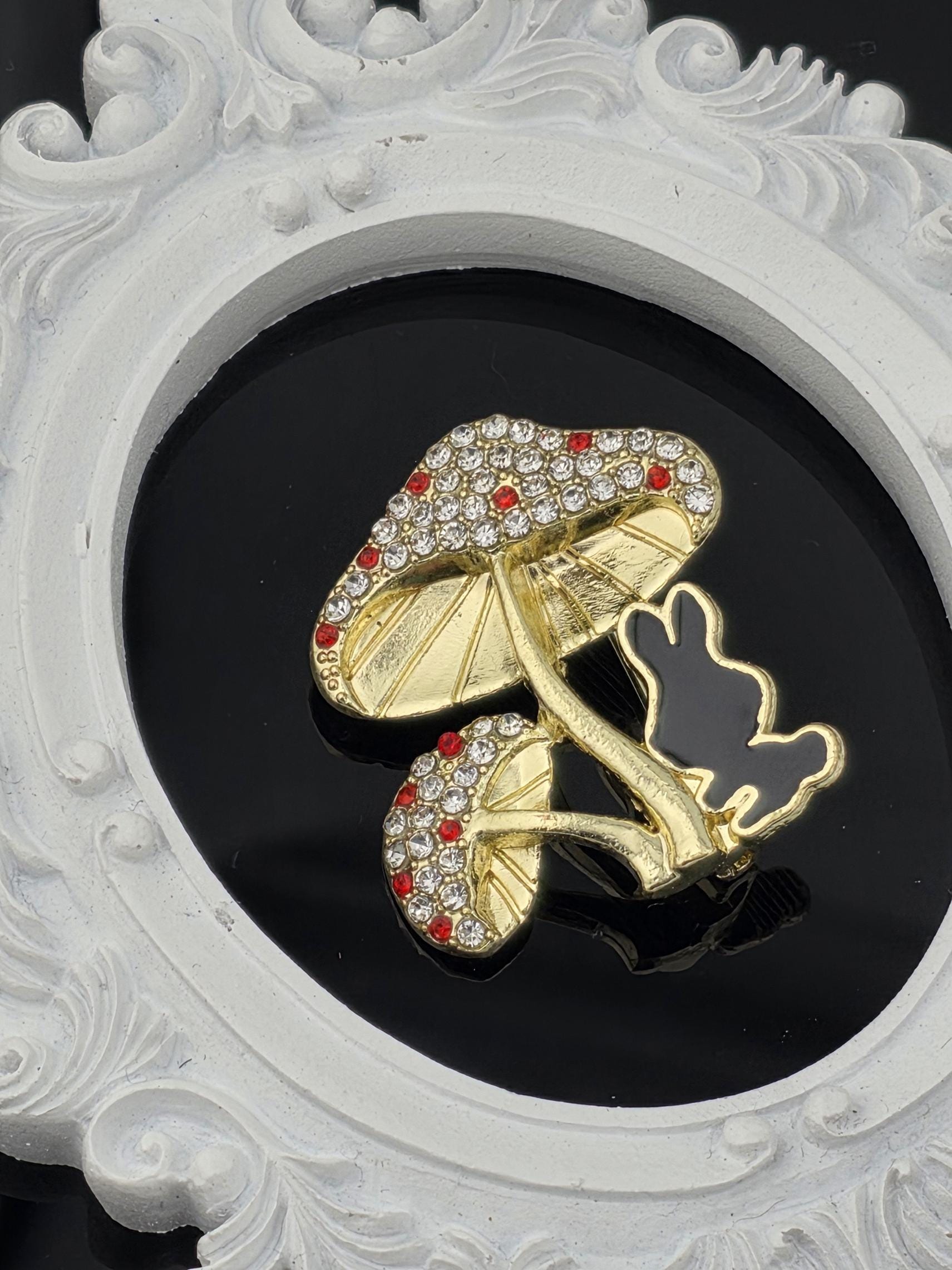 A decorative gold and diamond-encrusted shoe is displayed against a black background, framed by an ornate white border.