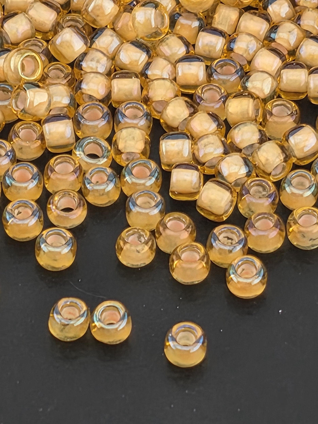 a close-up view of numerous small, clear glass beads scattered on a dark surface.