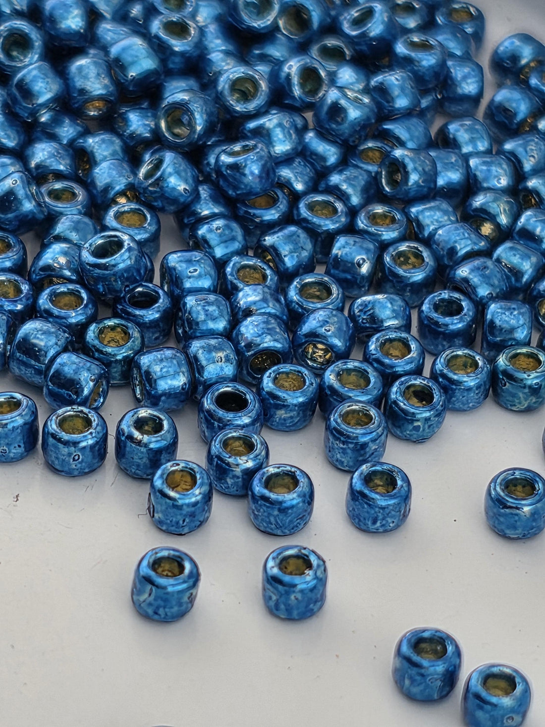 a collection of blue and yellow beads scattered across a surface.